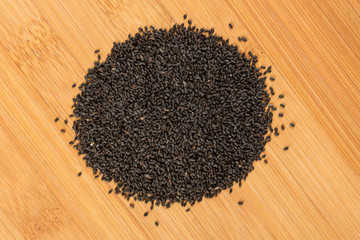 Dried basil seeds isolated on a wood background