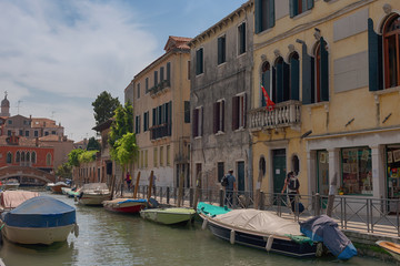 Fototapeta na wymiar Traditional narrow canal street with gondolas and old houses in Venice, Italy. Architecture and landmarks of Venice. Beautiful Venice postcard.