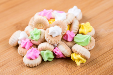 Small frosted cookies isolated on a wood background