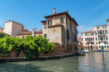 Traditional narrow canal street with gondolas and old houses in Venice, Italy. Architecture and landmarks of Venice. Beautiful Venice postcard.