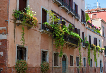 Fototapeta na wymiar VENICE, ITALY – MAY 23, 2017: Traditional beautiful venetian houses in a sunny summer day.