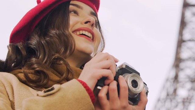 Attractive woman taking photos with camera, looking for a good shot, hobby
