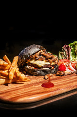 Beef charcoal black burger with french fries cheese and vegetable