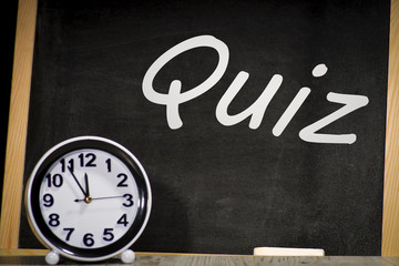 Quiz concept, inscription on a chalkboard and clock.