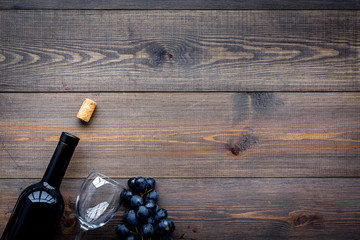 Drink wine concept. Bottle, glass, grape on wooden background top view copyspace