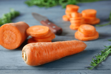 Tasty ripe carrot on wooden table, closeup