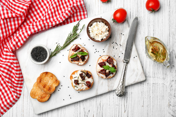 Tasty bruschettas with sun-dried tomatoes on board, top view