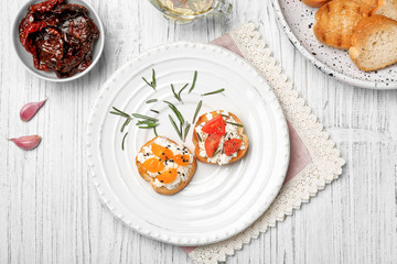 Tasty bruschettas with tomatoes on plate, top view