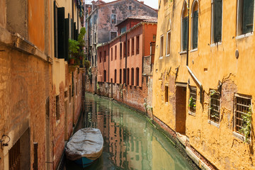 Traditional narrow canal street with gondolas and old houses in Venice, Italy. Architecture and landmarks of Venice. Beautiful Venice postcard.