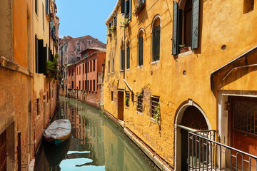 Obraz na płótnie Canvas Traditional narrow canal street with gondolas and old houses in Venice, Italy. Architecture and landmarks of Venice. Beautiful Venice postcard.