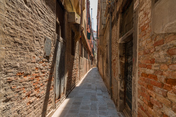 Beautiful venetian street with old houses in a sunny summer day.