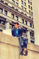 European businessman traveling, working in New York. A young guy with beard, sitting on street,...