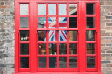 Fototapeta premium Fragment of brick wall and window with Union Jack flag