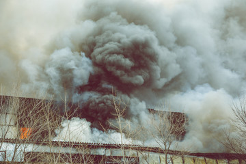 Fire in an industrial warehouse or Factory, lots of smoke and flames
