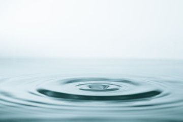 Water drop and splash on water surface on blue background