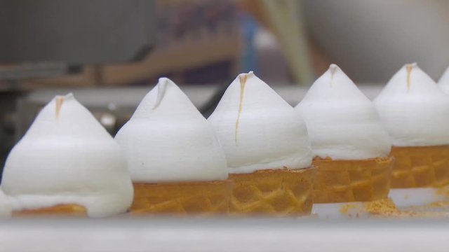 Automated production of ice cream. Ice cream factory. Ice cream in a cone. White plombir in a waffle cup.
