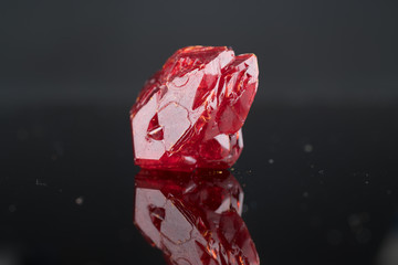 Red natural crystal mineral on a black background