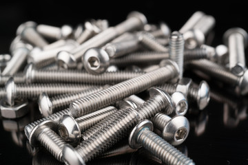 metal fasteners screws and nuts on black background. screw isolated on the black backgrounds. Nuts...
