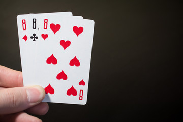 Abstract: man hand holding playing card three eight isolated on black background with copyspace poker set four eight