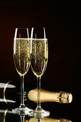 Champagne bottle with glasses on black background