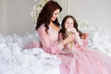 Mom and daughter in amazing dresses with flowers