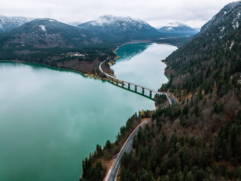 Aerial shot of lake Sylvenstein and it's bridge on a cloudy autumn day with mountains in in background