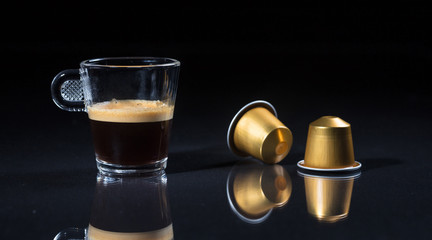 Espresso coffee cup and coffee pods on black background, Closeup view with details