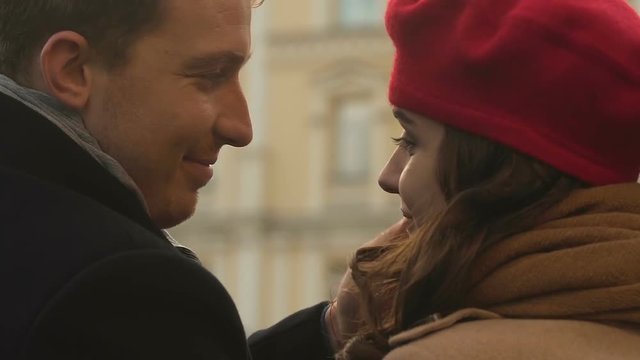 Kissing on first date, couple in love sitting outdoor, trusting relationship