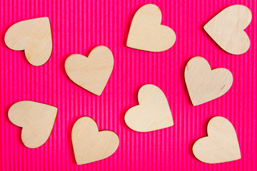 Hearts of wood on the pink corrugated background. Valentine's day background.