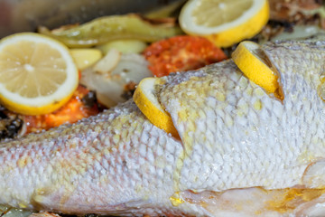 The cook puts some olive oil in Pagrus pagrus to cook it in the oven