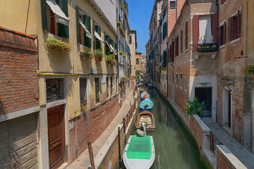 Fototapeta na wymiar Traditional narrow canal street with gondolas and old houses in Venice, Italy. Architecture and landmarks of Venice. Beautiful Venice postcard.