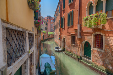 Traditional narrow canal street with gondolas and old houses in Venice, Italy. Architecture and landmarks of Venice. Beautiful Venice postcard.