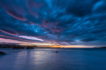 Fototapeta na wymiar spectacular and colorful sunset on the beach of Arnao
