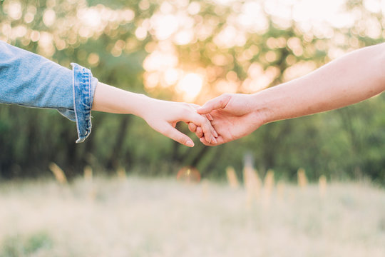 close-up of the hands of a guy and a girl who hold on to each other