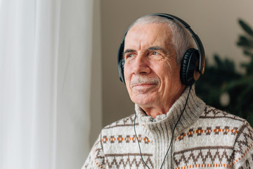Handsome Senior man listening music in headphones