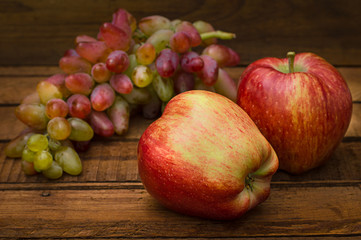 Apples and grapes on a wooden rustic background. Still life for thanksgiving with autumn fruits. Selective focus. Top view