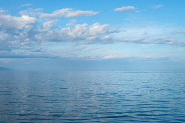Fototapeta premium Clear crystal water of Lake Baikal in calm weather . Blue sky and clouds reflection.
