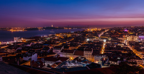 Breathtaking establishing shot of Lisbon, Portugal at dusk overseeing the entire downtown, the Tagus river, the Cristo Rei and the Ponte 25 de Abril suspension bridge.