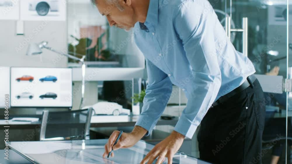 Poster experienced automotive designer works with digital display graphics tablet touschreen table, drawing