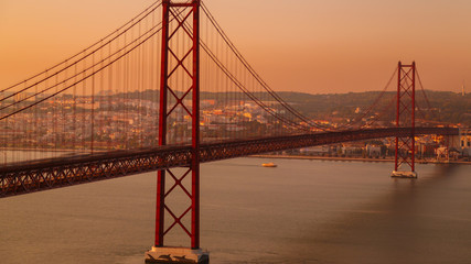 A dusk shot of the Ponte 25 de Abril suspension bridge in Lisbon, Portugal. The bridge connects Lisbon to Almada on the southbank of the Tagus.