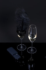 Black device and 2 glasses with champagne on a black background