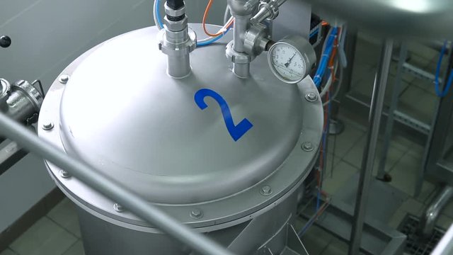 Industrial zone, Steel pipelines, valves, cables and walkways. Steel tanks in interior of a modern factory. Cooling system in the interior of a modern factory. Pressure gauge, measuring instrument.