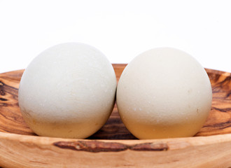 Unwashed fresh organic gmo and soy free pasture raised chicken eggs in wooden bowl isolated on white background