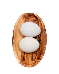 Unwashed fresh organic gmo and soy free pasture raised chicken eggs in wooden bowl isolated on white background