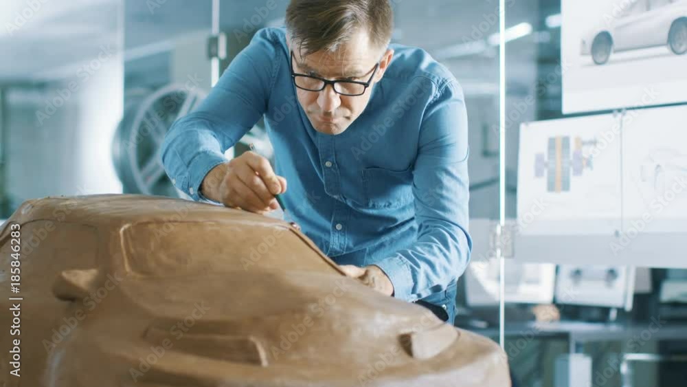 Poster experience automotive designer with a rake sculpts prototype car model from plasticine clay. he work