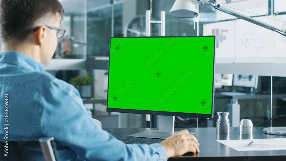 Poster Automotive Engineer Working on a Personal Computer With Isolated Mock-up Green Screen on it. Shot on RED EPIC-W 8K Helium Cinema Camera.