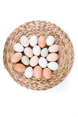 Farm fresh and commerical eggs on a woven mat