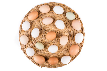 Farm fresh and commerical eggs on a woven mat