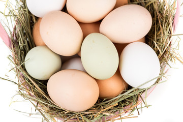 Easter basket filled with fresh and commercial eggs and hay