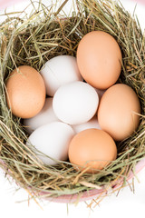Easter basket filled with fresh and commercial eggs and hay